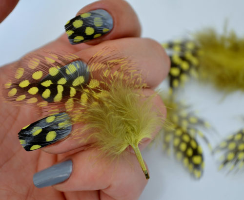 Yellow and black dotted feather nail art