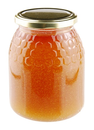 Homemade honey in a glass jar on white