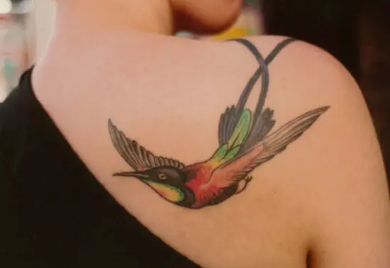 Watercolor style hummingbird tattoo located on the