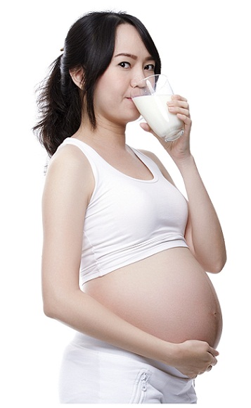 Pregnant woman drinking milk with turmeric