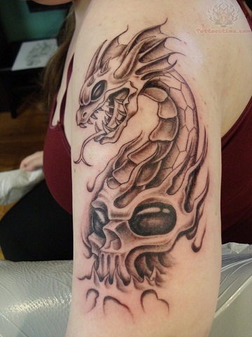 Shoulder skull tattoo with dragon teeth and scales
