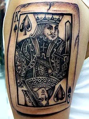 King card tattoo located on the shin blackwork style