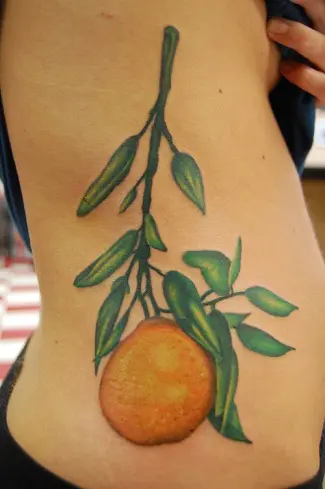 Single needle orange tattoo on the inner arm