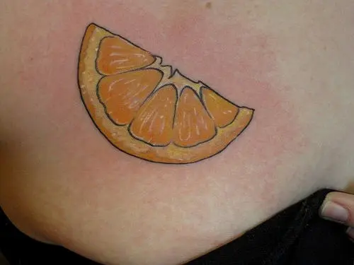 Traditional style orange tattoo located on the thigh
