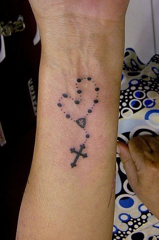 Praying hands with a rosary tattoo idea | TattoosAI