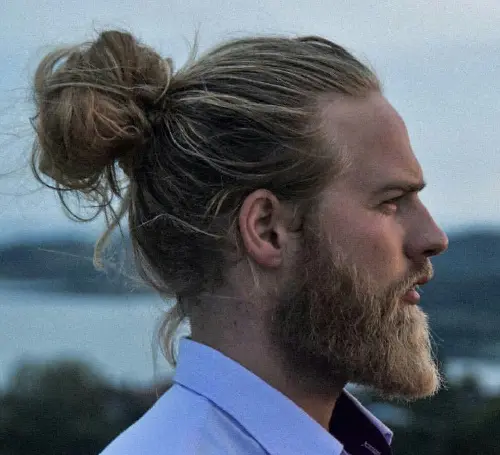A picture of a dapper Indian hipster with his long wavy hair in a cool man  bun hairstyle  Man Bun Hairstyle