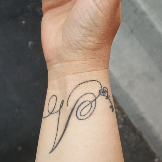 Minimalistic letter V tattoo for her son
