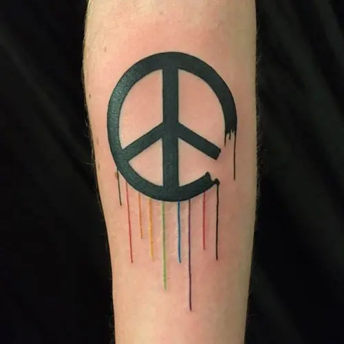 Tiny heart shaped peace symbol tattoo on the left