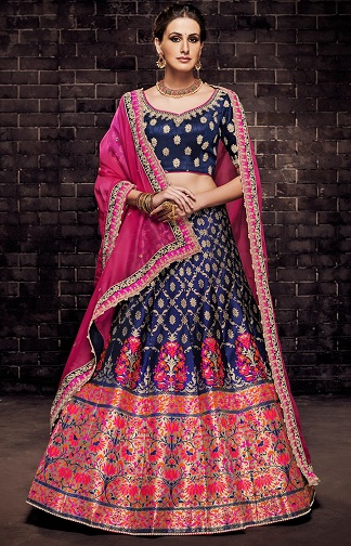The multi panelled brocade lehenga set in aubergine reds and oranges is  worn with a little