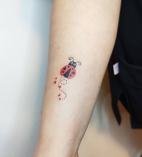Ladybug tattoo located on the inner forearm,