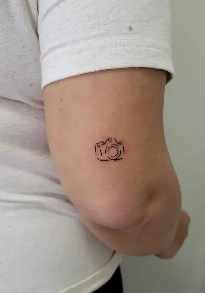 Tiny minimalistic camera tattooed on the finger
