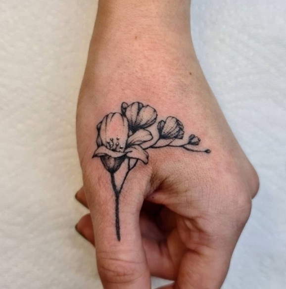 Small Freesia Tattoo Near The Thumb