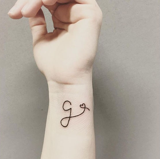 G Letter Tattoo With A Heart On The Wrist