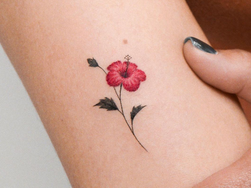 Tiny hibiscus tattoo located on the inner forearm.