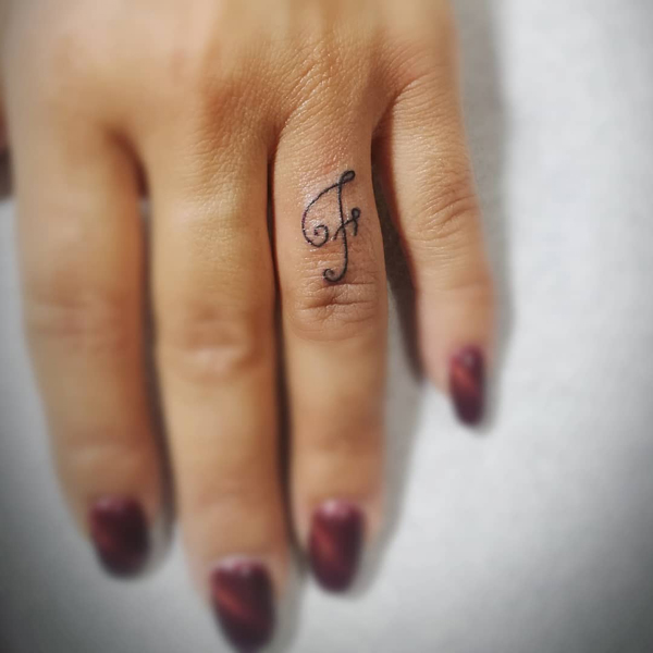 Cursive F Ring Finger Tattoo