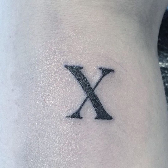 X Letter Tattoo On The Waist