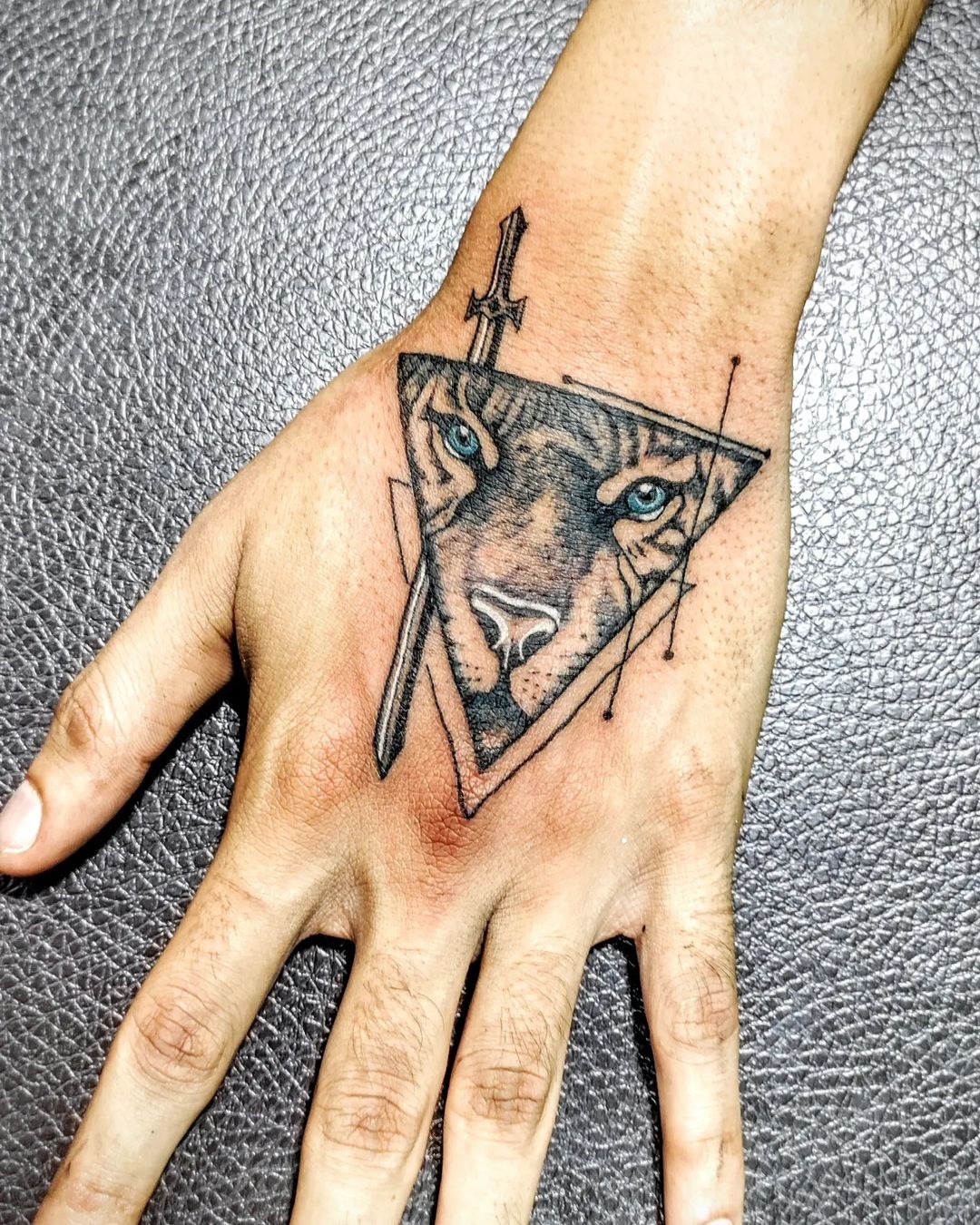 Geometric Precision Lion Hand Tattoo