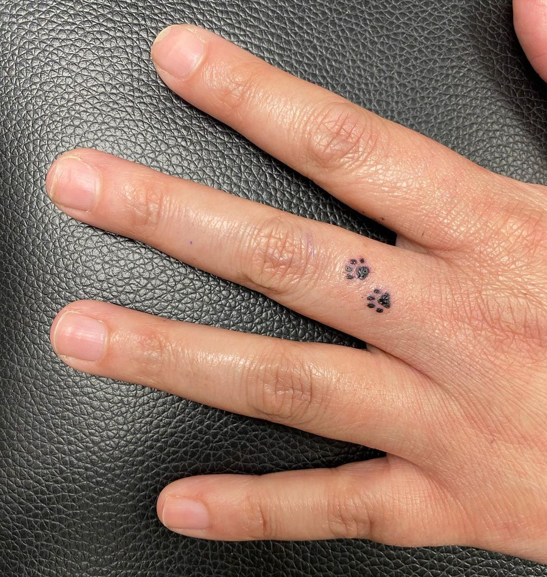 Tiny Paw Print Tattoo On Finger