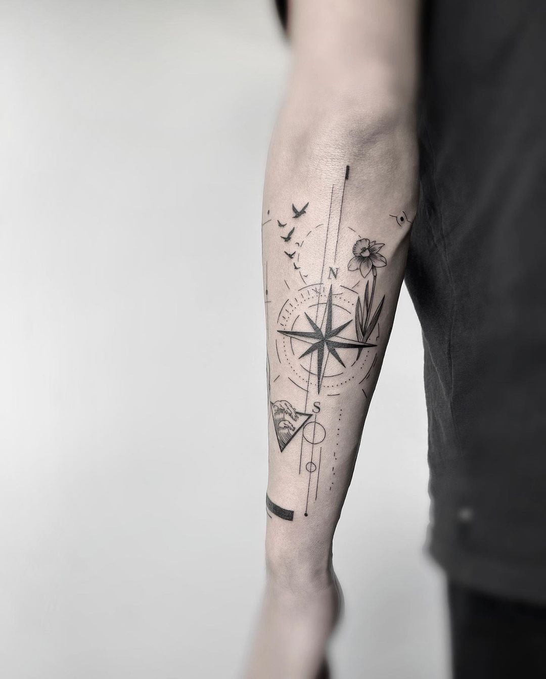 A Compass And Floral Tattoo On The Arm