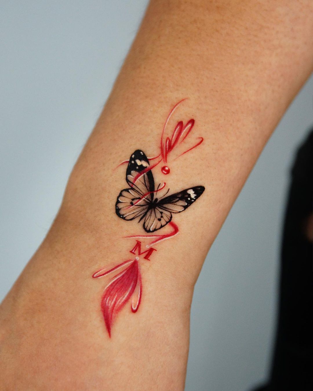 Red Accented Butterfly Wrist Tattoo With Initial