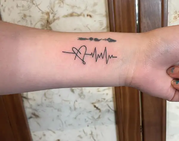 Wave heartbeat tattoo on the left bicep