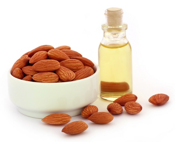 Fresh,almonds,with,bottle,of,oil,over,white,background