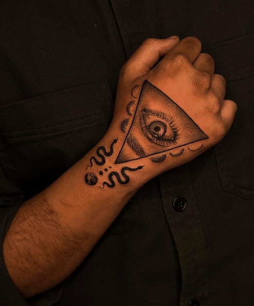 Fine line style evil eye tattoo placed on the back of