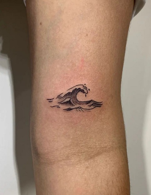 Minimalistic style wave tattoo located on the inner