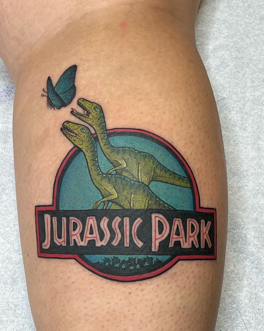 Colourful Jurassic Park Thigh Tattoo