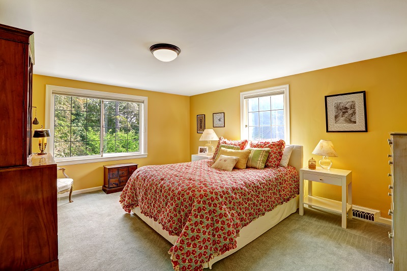 Cheerful,bedroom,interior,in,bright,yellow,color,and,red,bedding